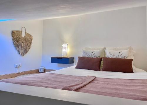 um quarto com uma grande cama branca com almofadas castanhas em Casa Coração do Bairro em Lisboa