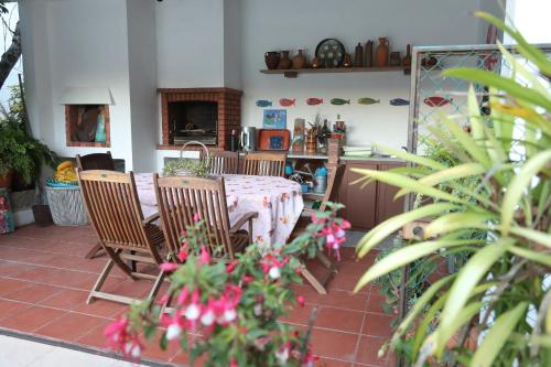 a dining room with a table and chairs and flowers at Sossego na cidade in Viseu