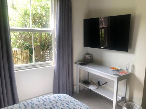 a bedroom with a bed and a window and a table at Elton in Cape Town