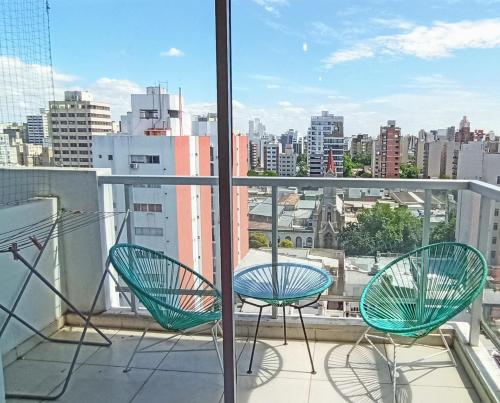 Un balcón con dos sillas y vista a una ciudad. en MaTilda Temporal La plata, en La Plata