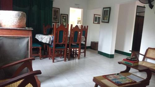 a living room with wooden chairs and a table at Las Cabanas de Pino Hostel in Santa Fe de Antioquia