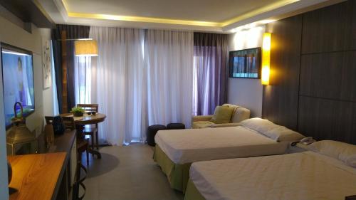 Habitación de hotel con 2 camas y mesa en Buzios Beach Resort Apartamento Luxo Home Premium en Búzios