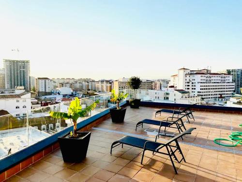 a balcony with chairs and tables on top of a building at Gibraltar Central Suites in Gibraltar