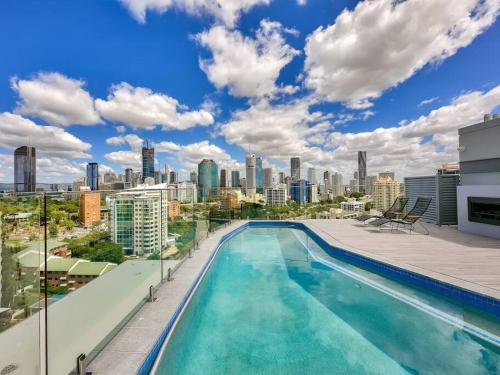 a swimming pool on top of a building with a city skyline at Lovely 2 Bedroom Executive Apartment in Brisbane