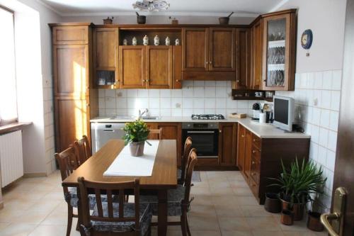 Trontanoにあるla casa nel prunentのキッチン(木製キャビネット、テーブル、椅子付)