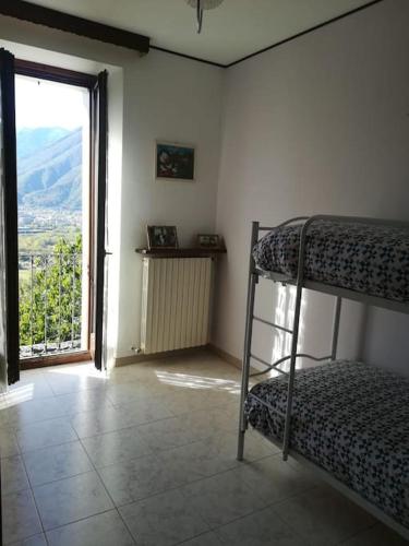 a room with a bunk bed and a large window at la casa nel prunent in Trontano