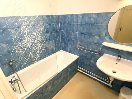 ein blau gefliestes Bad mit einer Badewanne und einem Waschbecken in der Unterkunft Studio Les Deux Alpes, 1 pièce, 4 personnes - FR-1-516-172 in Les Deux Alpes