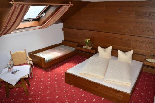 a small room with two beds and a window at Pension Spiegl in Seefeld in Tirol