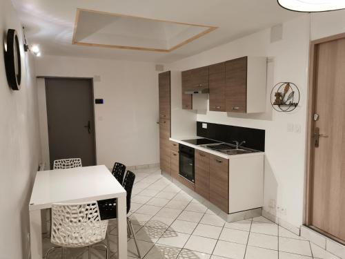 a kitchen with a table and some chairs and a table and a counter at Au Petit Bonheur Malouin in Malo-les-Bains