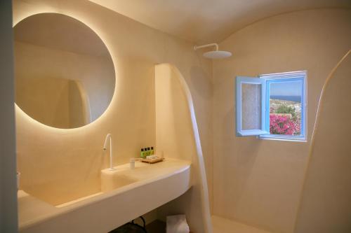 a bathroom with a sink and a window at SunSea Living Suites in Vourvoulos