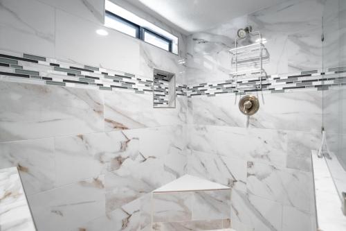 a bathroom with white marble walls and a shower at Beautiful Palm Springs Home large private yard in Palm Springs