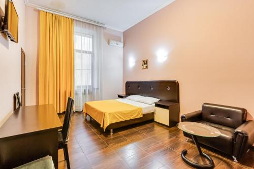 a hotel room with a bed and a table and a chair at Ostrovsky Hotel in Rostov on Don