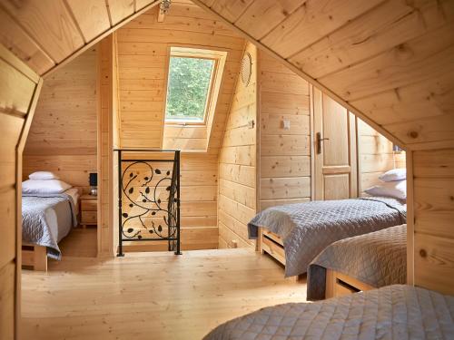 um quarto com 2 camas num chalé de madeira em Pienińska Chata em Krościenko