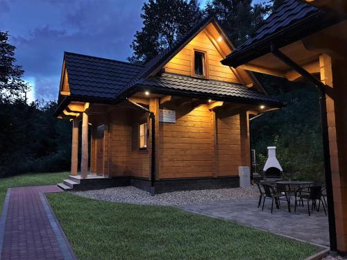 a wooden cabin with a table in the yard at Pienińska Chata in Krościenko