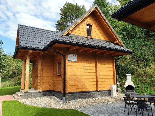 a small wooden cabin with a table and chairs at Pienińska Chata in Krościenko