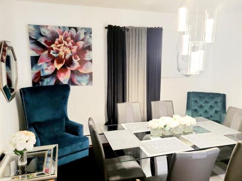 斯普林菲爾德的住宿－Fearlessrose vacation Rental，一间设有玻璃桌和蓝色椅子的用餐室
