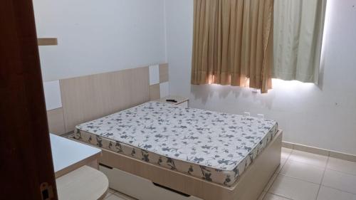 ein kleines Schlafzimmer mit einem Bett in einem Zimmer in der Unterkunft Águas da Serra Apart Hotel in Rio Quente
