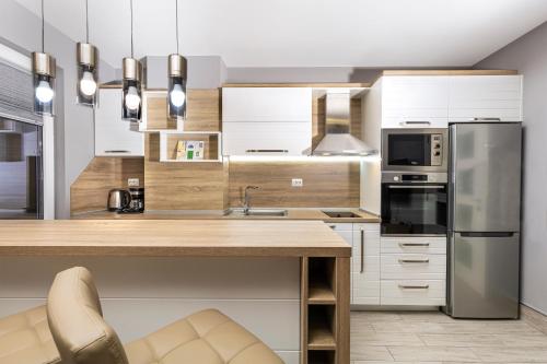 eine Küche mit weißen Schränken und Küchengeräten aus Edelstahl in der Unterkunft Beautiful 1BD Apartment with a Parking Spot in Plowdiw