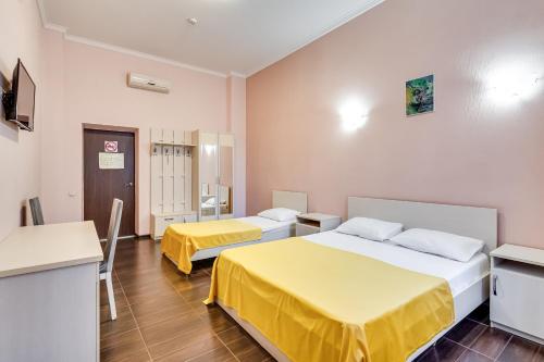 a hotel room with two beds and a kitchen at Ostrovsky Hotel in Rostov on Don
