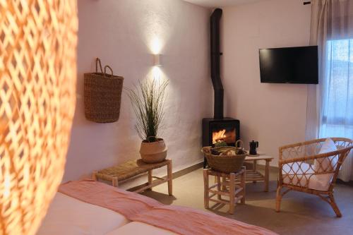 - un salon avec un lit et une cheminée dans l'établissement Apartamentos Cortijo Peñardera, à Siles