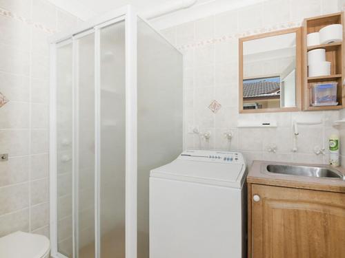 a bathroom with a sink and a washing machine at Werrina Townhouse in The Entrance