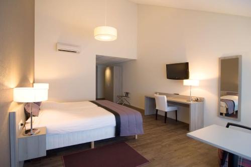 AduardにあるBest Western Plus Hotel Restaurant Aduardのベッド、デスク、テレビが備わるホテルルームです。