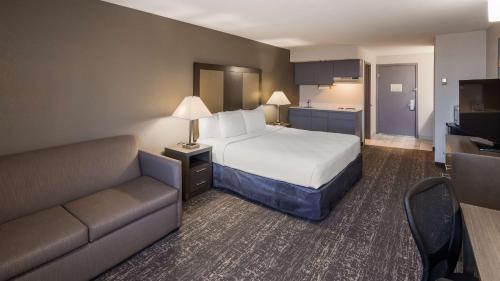 a hotel room with a bed and a couch at Baymont by Wyndham Moses Lake in Moses Lake