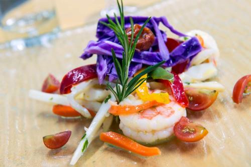 a plate of food with shrimp and vegetables on it at Radisson Blu Mammy Yoko Hotel in Freetown