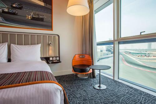 a hotel room with a bed and a table and a window at Park Inn by Radisson Dubai Motor City in Dubai