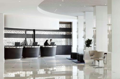 a lobby with two people sitting at a counter at Radisson Blu Hotel, Kuwait in Kuwait
