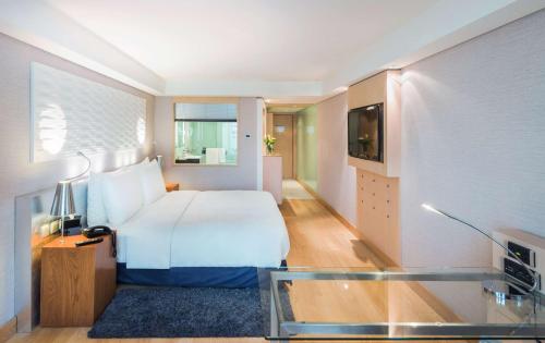 a hotel room with a bed and a tv at Radisson Blu Hotel, Kuwait in Kuwait