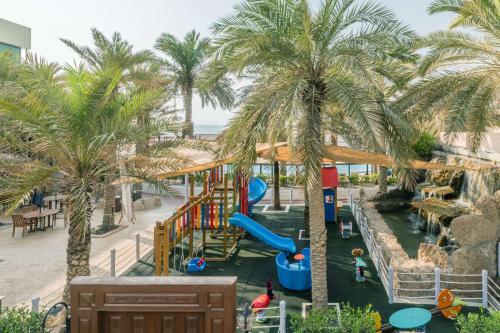 a water park with a slide and palm trees at Radisson Blu Hotel, Kuwait in Kuwait