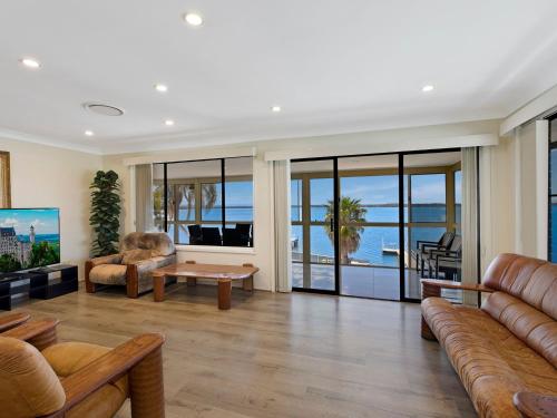a living room with a couch and a table at Toukley Waterfront House in Toukley