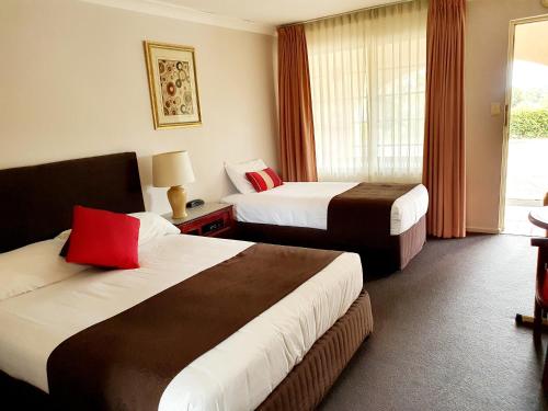 um quarto de hotel com duas camas e uma janela em McNevins Warwick Motel em Warwick