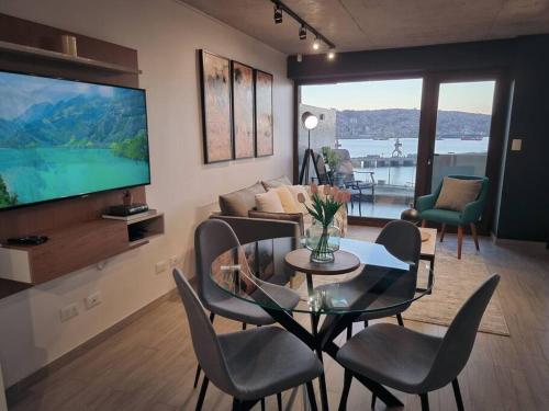 a living room with a television and a table and chairs at Nuevo Departamento Vive Barón Valparaíso in Valparaíso