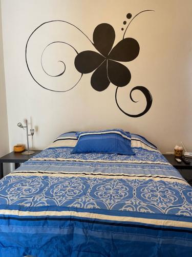 a bedroom with a bed with a flower on the wall at Casa en Puerto Vallarta con todos los servicios. in Puerto Vallarta