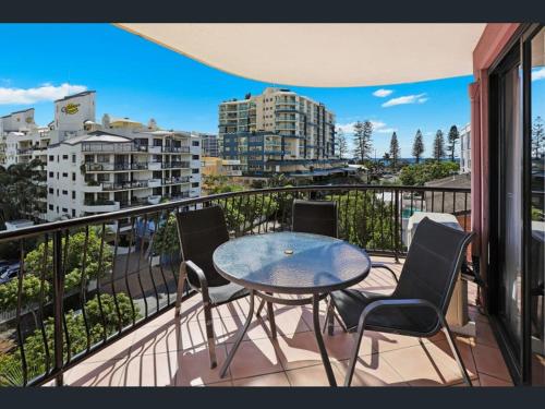 a table and chairs on a balcony with a view of a city at Nautilus Resort Mooloolaba in Mooloolaba