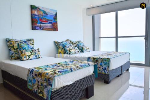 a bedroom with two twin beds and a couch at MORROS CITY ESPECTACULAR FRENTE A LA PLAYA in Cartagena de Indias