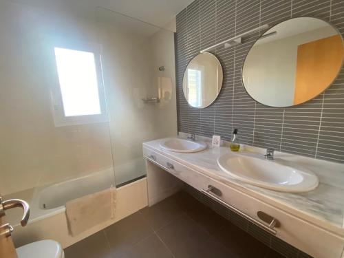 a bathroom with two sinks and a mirror and a tub at Casa Rural Cascadas del Hueznar in San Nicolás del Puerto