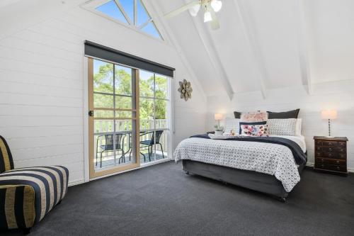 ein weißes Zimmer mit einem Bett und einem Fenster in der Unterkunft Creek Cottage Bed and Breakfast Traralgon in Traralgon