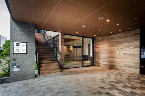 a lobby of a building with glass doors and stairs at Tokyu Stay Shinjuku Eastside in Tokyo