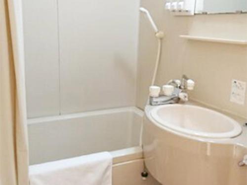 a bathroom with a sink and a toilet and a shower at City Inn Nishi Tanabe in Osaka