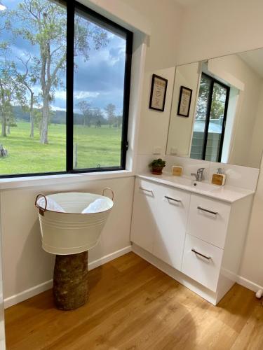 a bathroom with a tub and a sink and a window at Stay at the Barn... Immerse yourself in nature. in Kenilworth