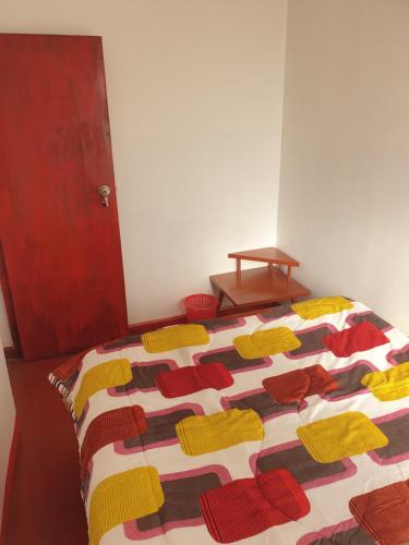 a bed with a colorful quilt on top of it at SK Hostal in Cusco