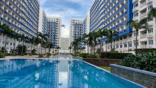 a swimming pool in the middle of two tall buildings at MSH property Sea Residences MOA Pasay City by Queennie in Manila