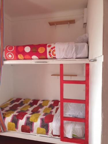 a bunk bed with a ladder in a room at SK Hostal in Cusco