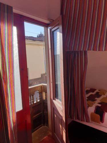 a room with a bedroom with a window and a bed at SK Hostal in Cusco