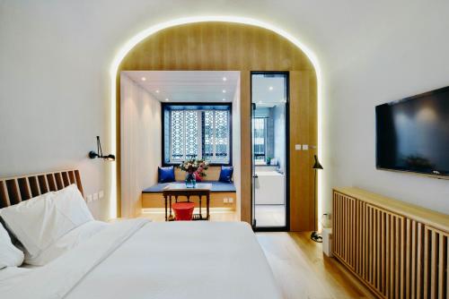 a bedroom with a bed and a bathroom with a sink at 7Shang in Beijing