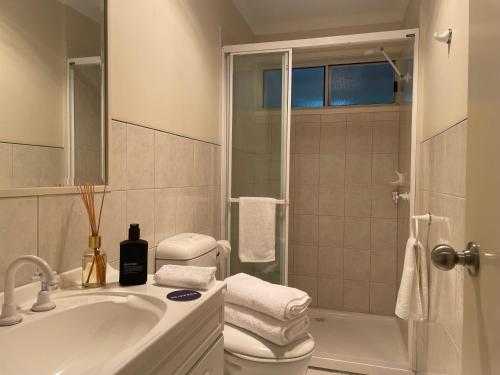 a bathroom with a toilet and a sink and a shower at Skippers Apollo Bay in Apollo Bay