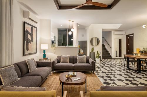 a living room with couches and a table at La Zamora, 3BHK Villas near Vagator & Anjuna Beach, North Goa with Private Pool, Garden, Terrace & Security in Assagao